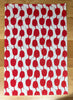 Tea towel with red and white pattern on a wooden surface